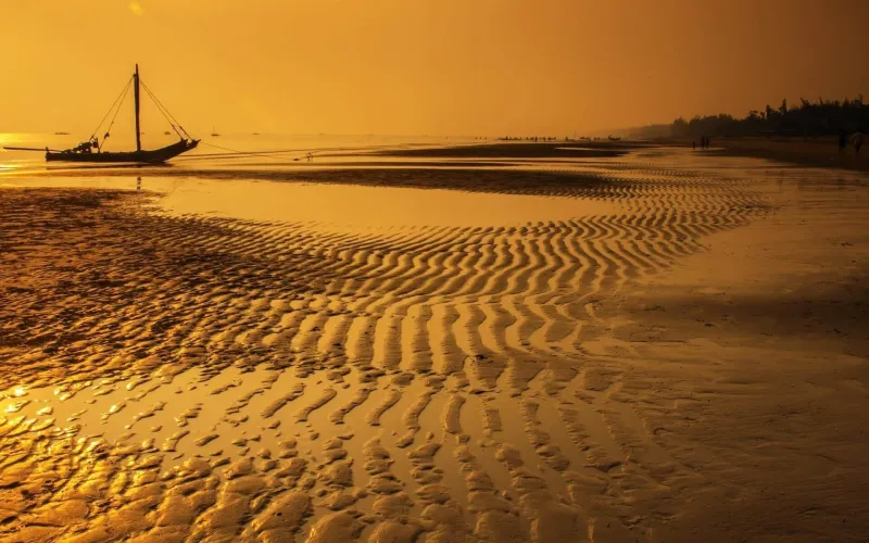 En båt på en strand med lågt tidvatten