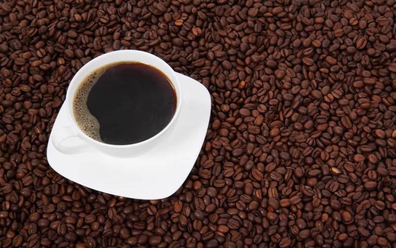 En kopp kaffe på en bädd av kaffebönor