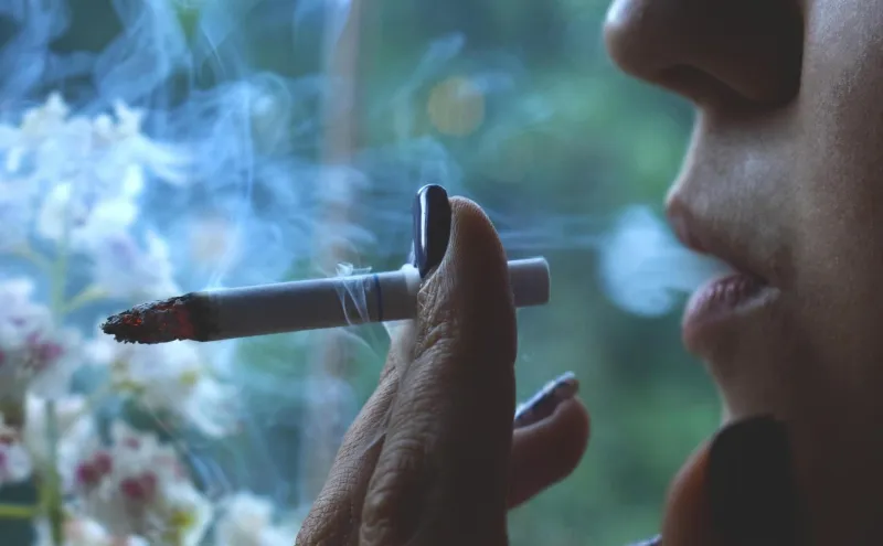 Närbild på en kvinna som röker en cigarett